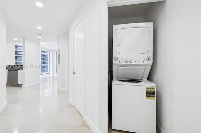 washroom with stacked washer / dryer, light tile patterned floors, laundry area, baseboards, and recessed lighting
