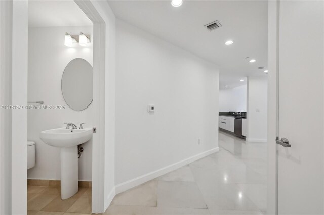 bathroom with baseboards, visible vents, and recessed lighting