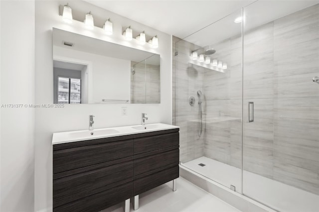 bathroom with a shower stall, visible vents, double vanity, and a sink