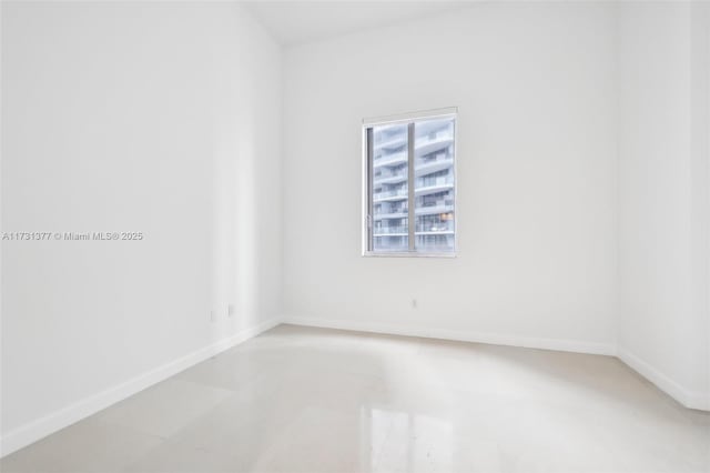 unfurnished room with baseboards