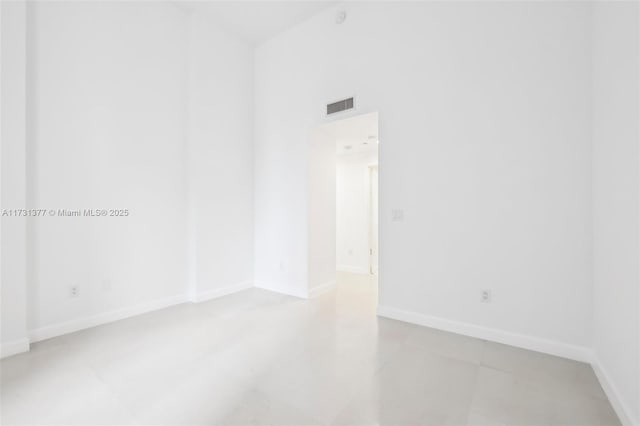unfurnished room with light tile patterned floors, visible vents, and baseboards