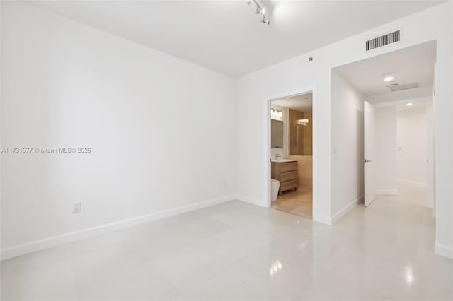 unfurnished room featuring track lighting, light tile patterned floors, visible vents, and baseboards