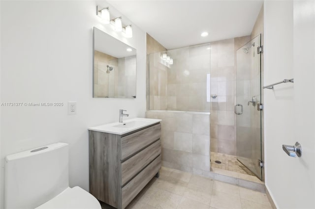 bathroom featuring a stall shower, recessed lighting, vanity, and toilet