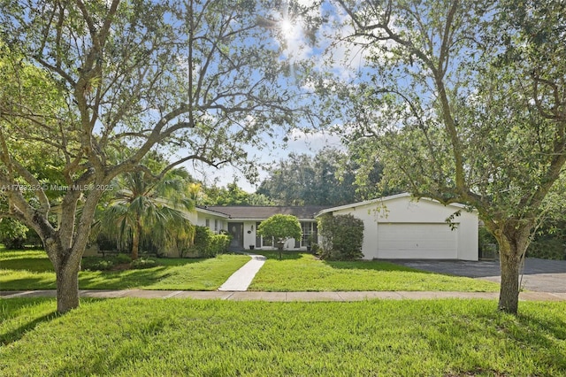 ranch-style home with a garage and a front lawn