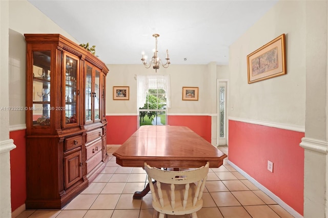 tiled dining room with a chandelier