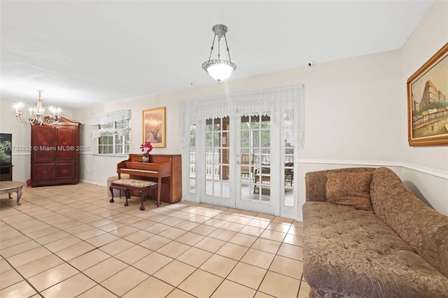 living room with a notable chandelier, french doors, and light tile patterned flooring