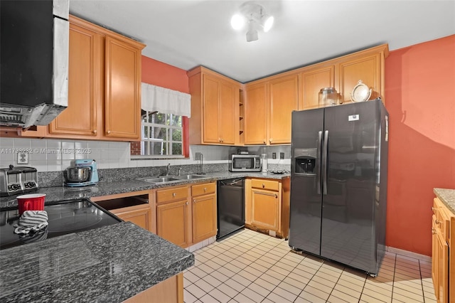 kitchen featuring sink, light tile patterned floors, dark stone countertops, backsplash, and stainless steel appliances