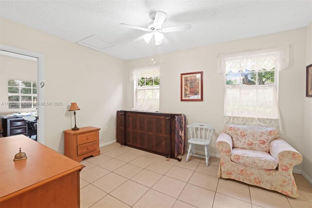 tiled bedroom featuring ceiling fan and a textured ceiling