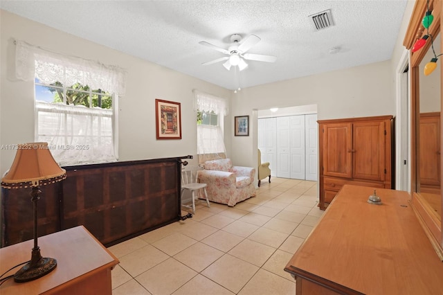 tiled living room featuring ceiling fan and a textured ceiling