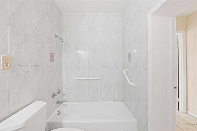 bathroom featuring tiled shower / bath combo, tile patterned floors, and toilet