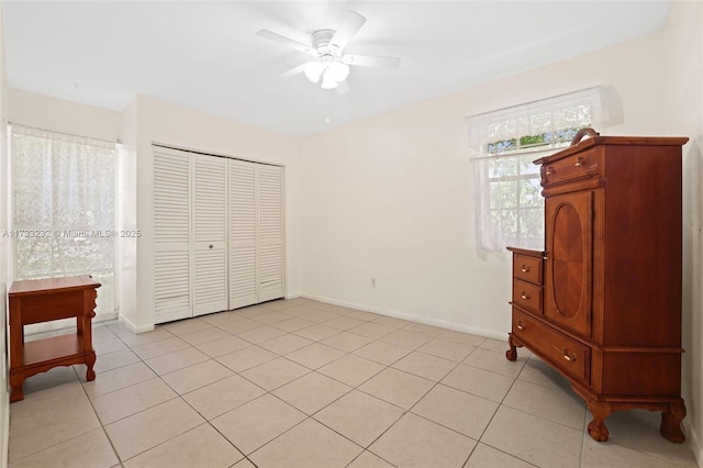 bedroom featuring ceiling fan, a closet, and light tile patterned floors