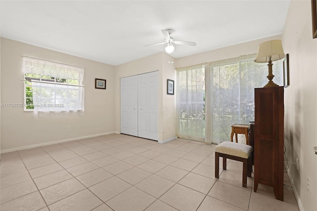 living area featuring light tile patterned floors and ceiling fan