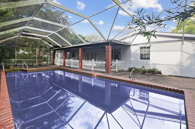 view of swimming pool featuring ceiling fan and a lanai