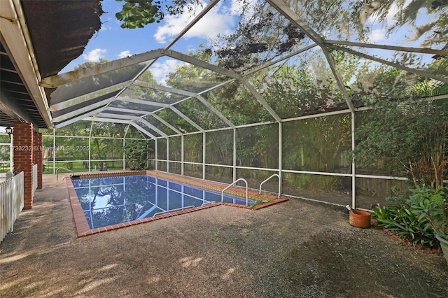 view of pool featuring glass enclosure and a patio area