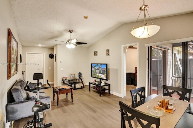 dining space featuring ceiling fan, light hardwood / wood-style flooring, a textured ceiling, and vaulted ceiling