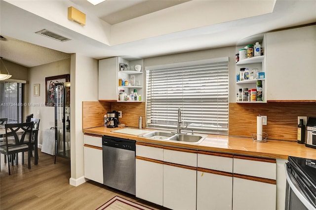 kitchen with white cabinetry, stainless steel dishwasher, light hardwood / wood-style floors, and sink