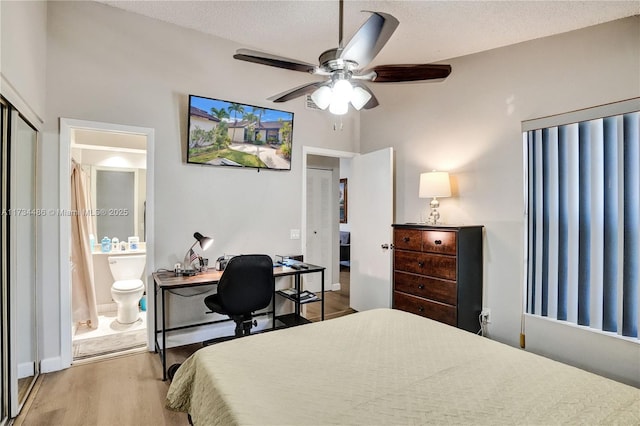 bedroom featuring ensuite bath, ceiling fan, wood-type flooring, a textured ceiling, and a closet