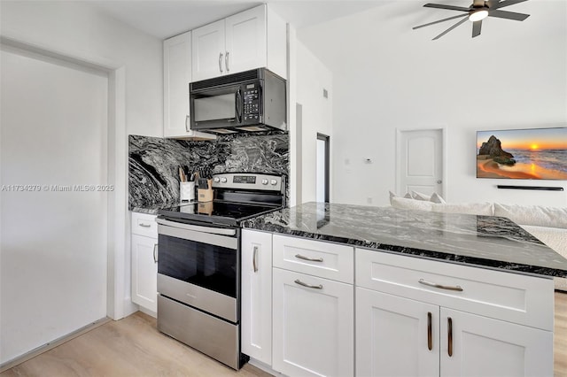 kitchen featuring dark stone countertops, backsplash, electric range, light hardwood / wood-style floors, and white cabinets