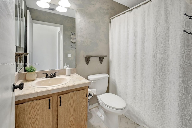 bathroom featuring vanity, tile patterned floors, and toilet