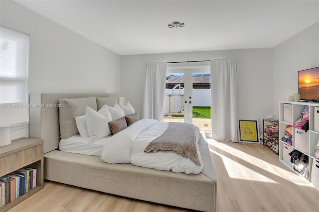 bedroom with access to exterior, french doors, and light wood-type flooring