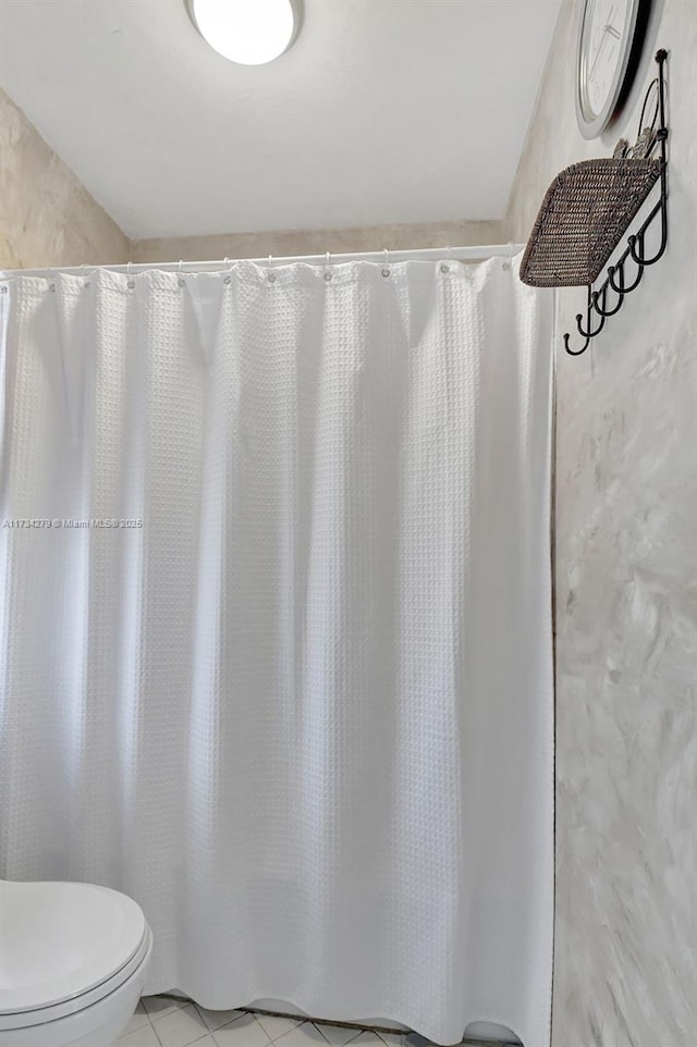 bathroom with walk in shower, tile patterned floors, and toilet