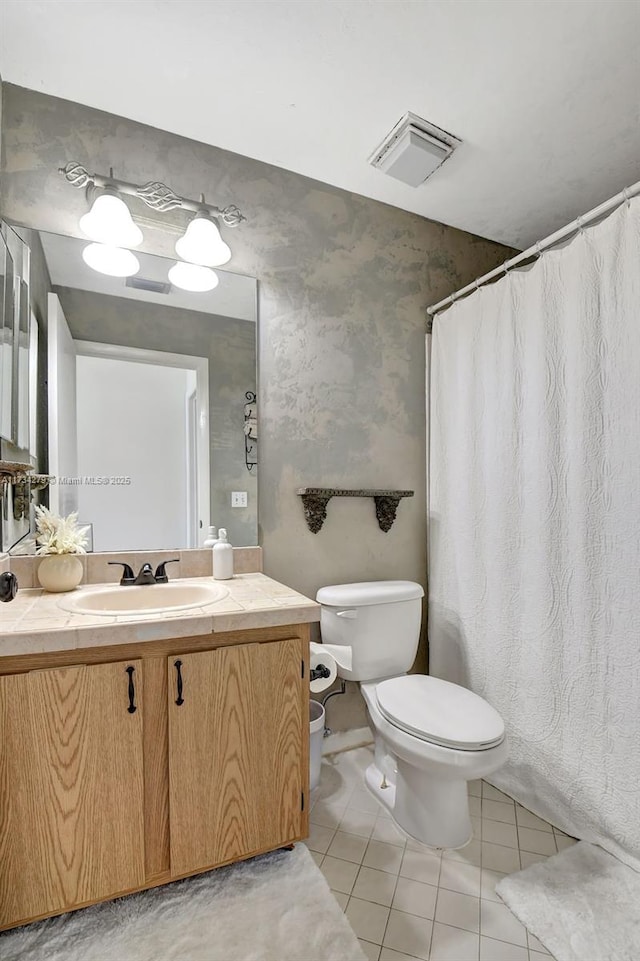 bathroom with tile patterned flooring, vanity, and toilet