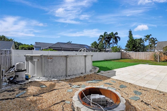 view of yard with a fenced in pool, a patio, and an outdoor fire pit