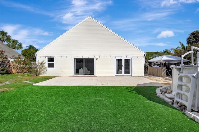 back of property with a patio and a yard