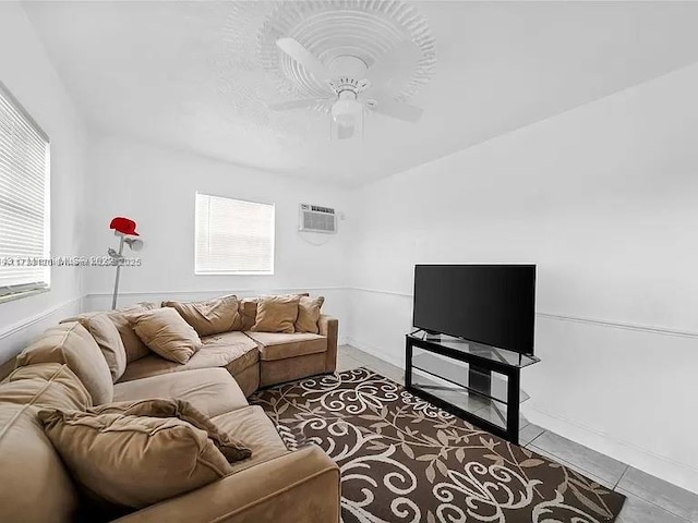 living room featuring a wall mounted AC, tile patterned floors, and ceiling fan