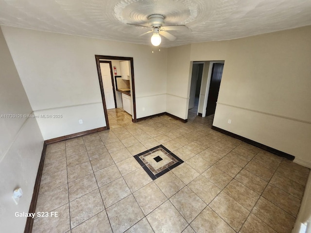 tiled empty room featuring ceiling fan