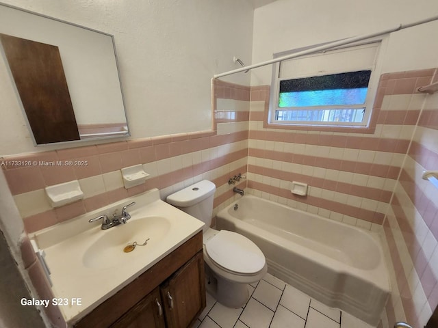 full bathroom with tile patterned flooring, tile walls, tiled shower / bath combo, vanity, and toilet