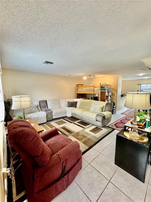 living room with light tile patterned flooring and a textured ceiling