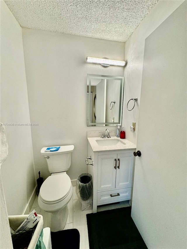 bathroom featuring vanity, a textured ceiling, and toilet