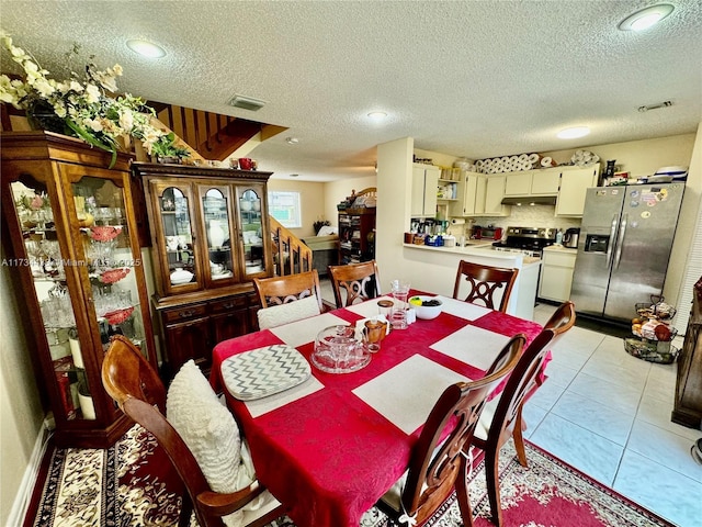 dining space with light tile patterned floors and a textured ceiling