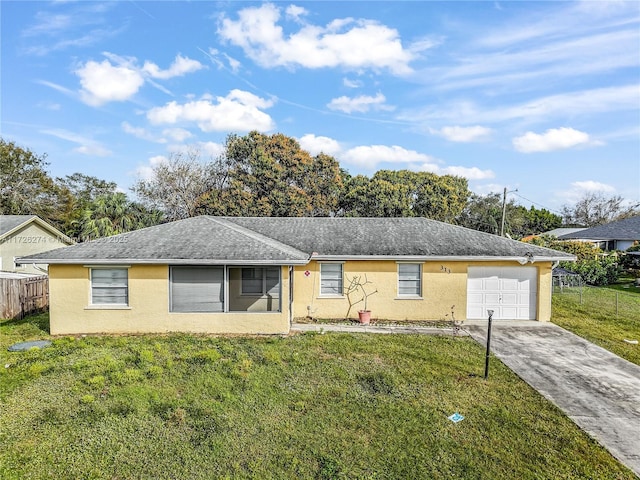 ranch-style home featuring driveway, an attached garage, fence, a front yard, and stucco siding