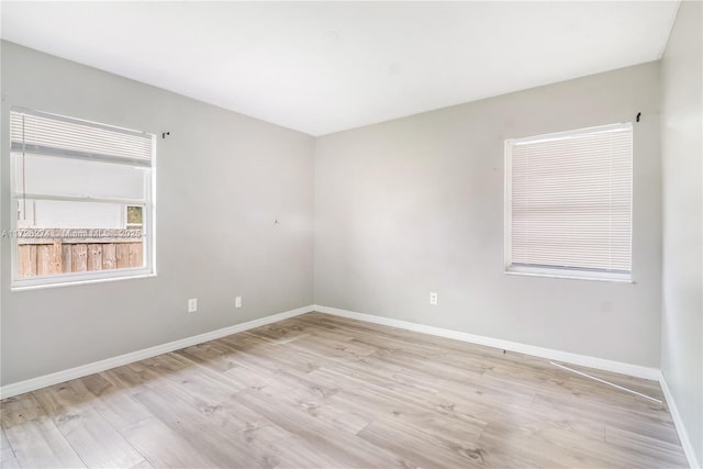 empty room featuring baseboards and light wood finished floors