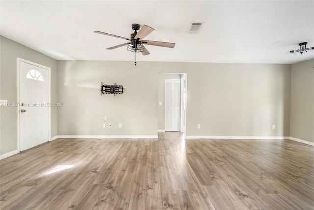 unfurnished room featuring light wood finished floors, baseboards, visible vents, and a ceiling fan