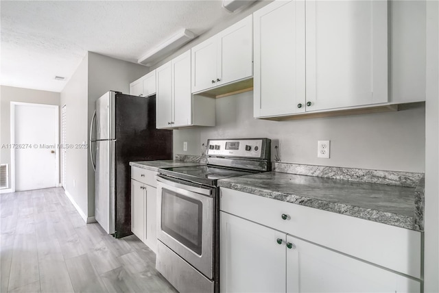 kitchen with white cabinets, dark countertops, stainless steel appliances, and a textured ceiling