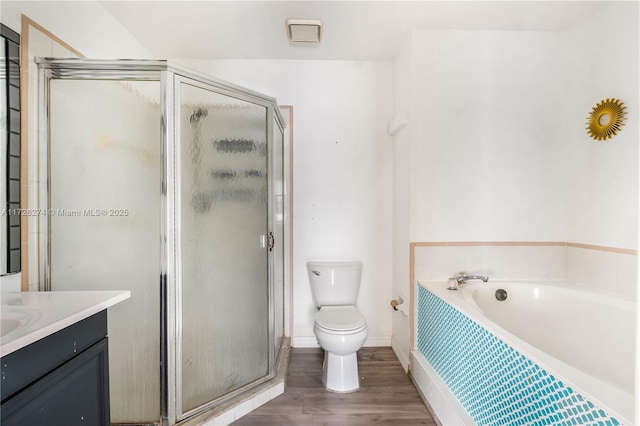 full bath with toilet, a stall shower, wood finished floors, and vanity