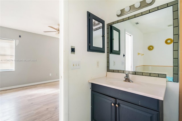 bathroom featuring baseboards, visible vents, ceiling fan, wood finished floors, and vanity