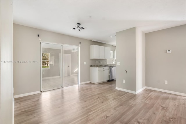 unfurnished living room featuring light wood-style flooring, baseboards, and ceiling fan