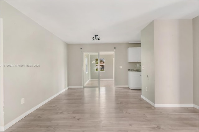 unfurnished room featuring light wood-type flooring and baseboards