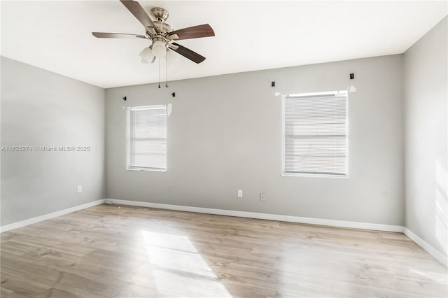 spare room with light wood-style floors, baseboards, and a ceiling fan