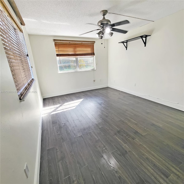 empty room with ceiling fan, dark hardwood / wood-style floors, and a textured ceiling