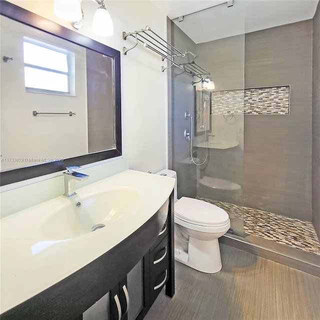 bathroom with vanity, a tile shower, and toilet