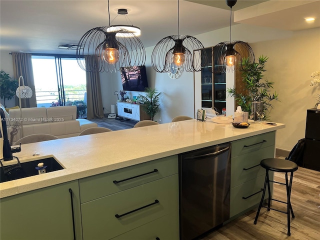 kitchen with hardwood / wood-style flooring, green cabinets, hanging light fixtures, fridge, and a kitchen breakfast bar