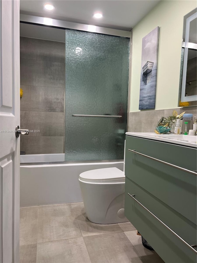 full bathroom featuring shower / bath combination with glass door, vanity, and toilet