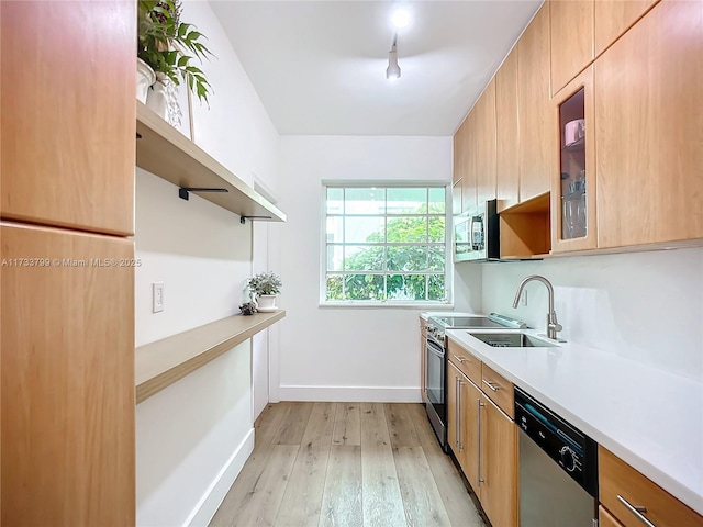 kitchen featuring stainless steel appliances, sink, and light hardwood / wood-style flooring