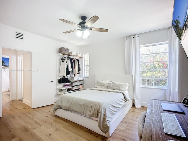 bedroom with ceiling fan, a closet, and light hardwood / wood-style flooring