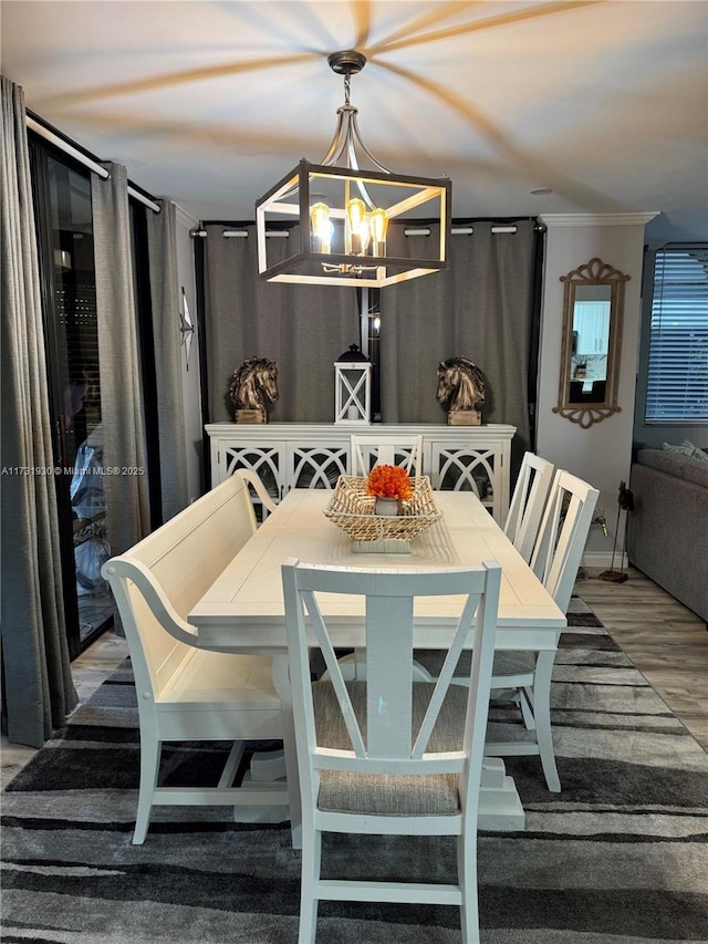 dining area with an inviting chandelier, hardwood / wood-style floors, and ornamental molding